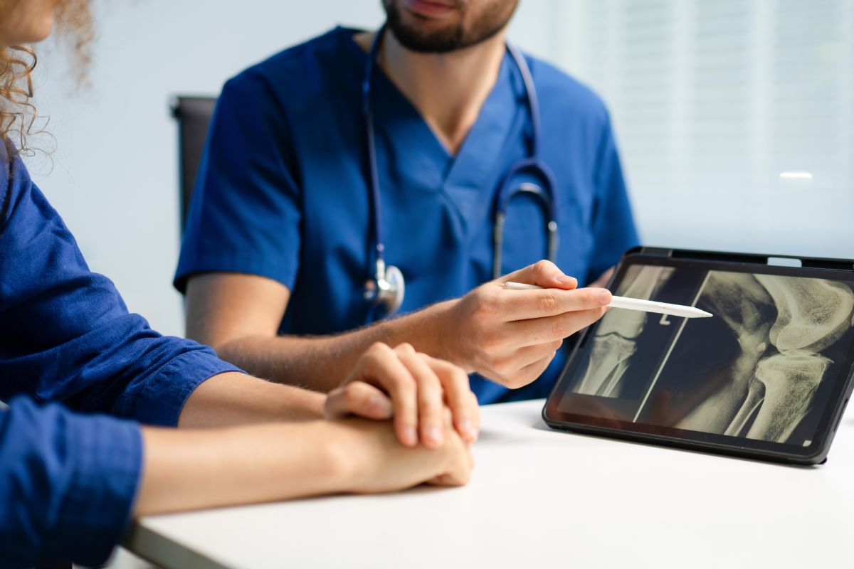 A professional medical consultation at Midtown Occupational Health in Denver, where a Level II physician is reviewing a recovery plan with an employee to ensure a safe and sustainable return to work.